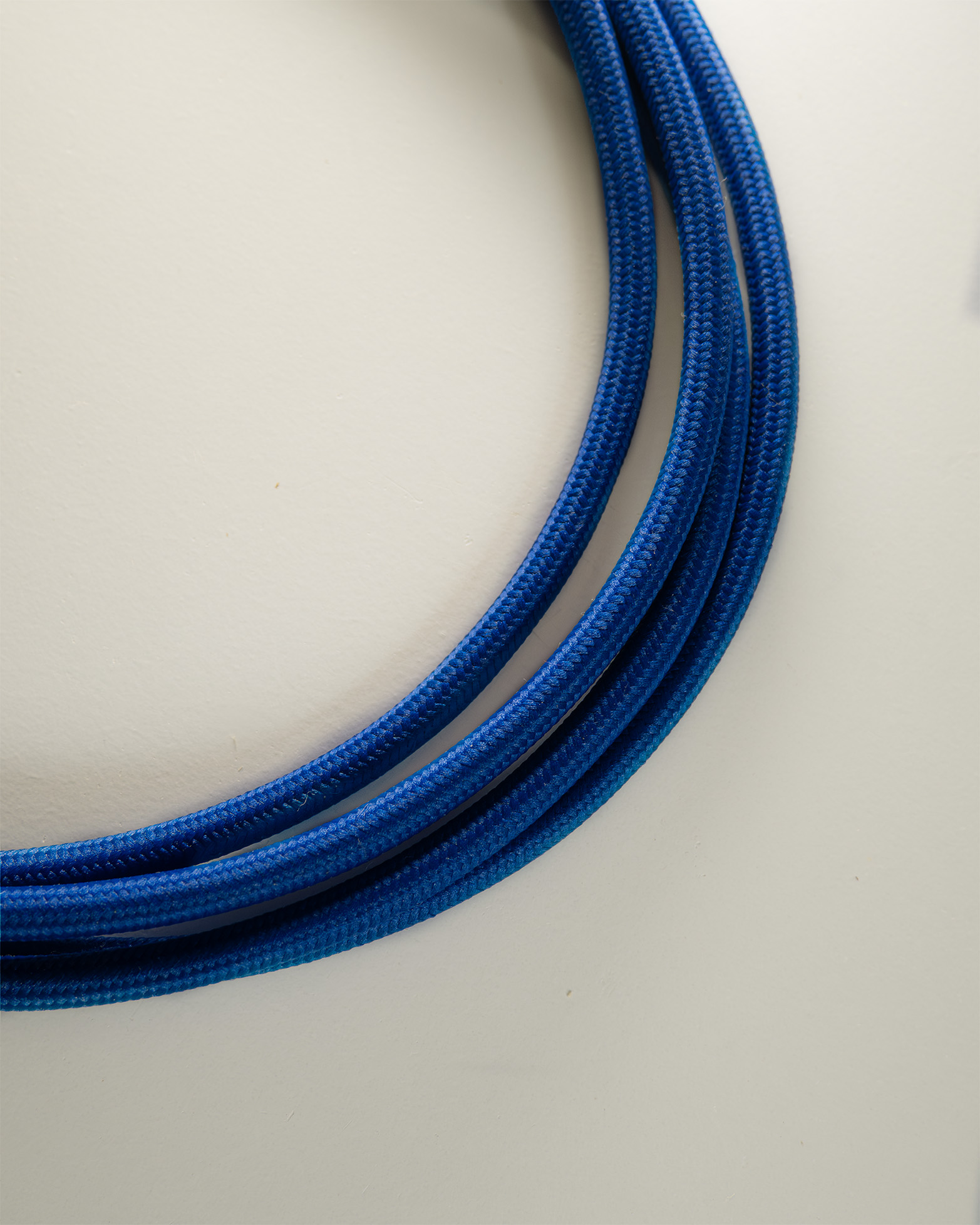 Câble électrique textile bleu électrique monté sur luminaire en bois
