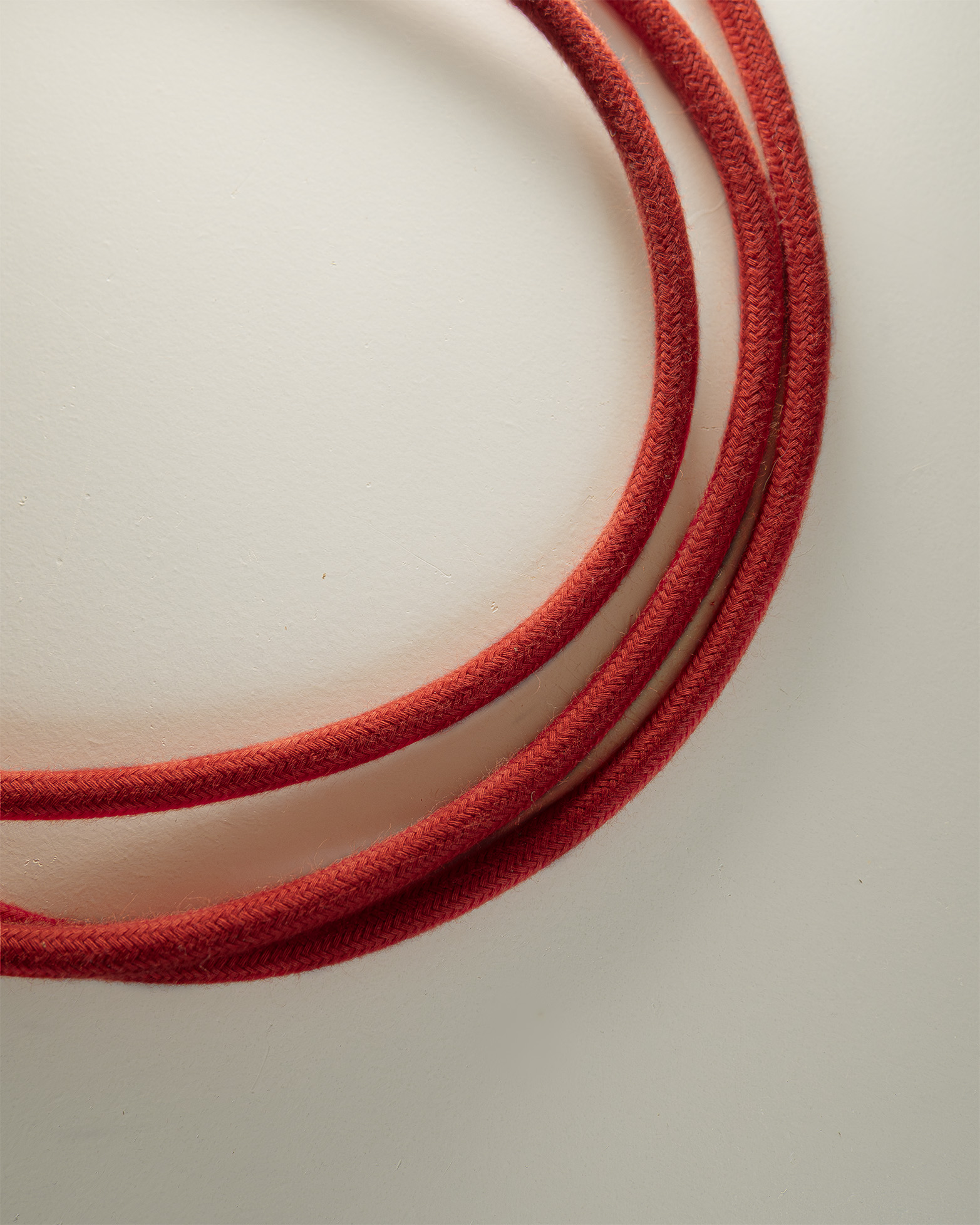 Câble électrique textile rouge vif monté sur luminaire en bois